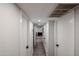 Hallway featuring white walls, tile floors, and white doors with black handles at 3520 E Ludlow Dr, Phoenix, AZ 85032