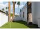 Backyard putting green surrounded by palm trees and a modern white home exterior at 4120 N 44Th Pl, Phoenix, AZ 85018