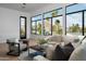 Inviting living room with large windows showcasing palm trees and mountain views, plus a comfortable sectional sofa at 4120 N 44Th Pl, Phoenix, AZ 85018
