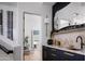 Wet bar with black cabinets, gold hardware, and marble countertop adjacent to a contemporary wine cellar at 4120 N 44Th Pl, Phoenix, AZ 85018