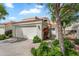Charming home featuring a two-car garage, driveway, and desert landscaping, all set against a backdrop of blue sky and mature trees at 4225 N 21St St # 22, Phoenix, AZ 85016