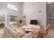 Bright living room featuring vaulted ceilings, light wood floors, and sliding glass doors to backyard at 4714 E Angela Dr, Phoenix, AZ 85032