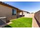Wide shot of the backyard with artificial grass and an extended patio at 5383 N 205Th Dr, Buckeye, AZ 85396