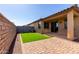 Backyard features patio, artificial grass, privacy wall, and brick pavers at 5383 N 205Th Dr, Buckeye, AZ 85396