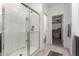 Bathroom featuring a clear glass shower, neutral tile floor, and open doorway to the walk-in closet at 5383 N 205Th Dr, Buckeye, AZ 85396