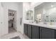 Bathroom featuring dual sinks, gray cabinets, quartz countertops, and a clear glass shower at 5383 N 205Th Dr, Buckeye, AZ 85396