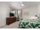 Well-lit bedroom with a full bed, leafy comforter, dresser, and neutral colored walls at 5383 N 205Th Dr, Buckeye, AZ 85396