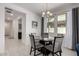 Dining area featuring a glass table, upholstered chairs, chandelier, and natural light at 5383 N 205Th Dr, Buckeye, AZ 85396