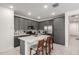 This kitchen features stainless appliances, gray cabinets, white countertops and a convenient kitchen island with seating at 5383 N 205Th Dr, Buckeye, AZ 85396