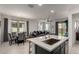 This kitchen features stainless appliances, gray cabinets, white countertops and an island with seating facing the dining area at 5383 N 205Th Dr, Buckeye, AZ 85396
