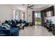 Cozy living room with a plush blue sofa, light tile flooring, and backyard access at 5383 N 205Th Dr, Buckeye, AZ 85396