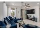 Inviting living room with a plush blue sofa, modern decor, and sliding glass doors at 5383 N 205Th Dr, Buckeye, AZ 85396