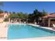 Community pool with lounge seating, covered patio area, and lush greenery creates a refreshing oasis at 5704 E Aire Libre Ave # 1036, Scottsdale, AZ 85254
