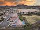 Expansive aerial view of a community with houses, a baseball field, and a backdrop of picturesque mountains at 5829 W Alyssa Ln, Phoenix, AZ 85083