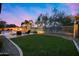 This backyard is a perfect entertainment space featuring a fire pit, pool and spa, seating area and green grass at 5829 W Alyssa Ln, Phoenix, AZ 85083