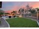 Enjoy the beautiful views from this backyard with green grass, palm trees, and seating area at 5829 W Alyssa Ln, Phoenix, AZ 85083