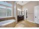 Bright bathroom features soaking tub, dual vanities, and access to walk-in closet at 5829 W Alyssa Ln, Phoenix, AZ 85083