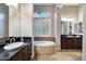 Elegant bathroom boasts dual vanities, a soaking tub, and travertine flooring at 5829 W Alyssa Ln, Phoenix, AZ 85083