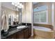 A spacious bathroom featuring dual vanities, granite counters, and a relaxing soaking tub at 5829 W Alyssa Ln, Phoenix, AZ 85083