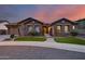 Charming stone home with manicured lawn and desert plants at dusk at 5829 W Alyssa Ln, Phoenix, AZ 85083