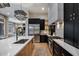 Modern kitchen with stainless steel appliances, a large island, black and gold cabinetry, and a stylish lighting fixture at 5829 W Alyssa Ln, Phoenix, AZ 85083