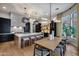 Elegant kitchen and dining area with a large island, custom cabinets, and stylish modern lighting fixtures at 5829 W Alyssa Ln, Phoenix, AZ 85083