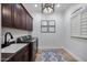 Modern laundry room features wooden cabinets, washer and dryer, and decor at 5829 W Alyssa Ln, Phoenix, AZ 85083