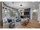 Open-concept living room with large windows, comfortable seating, and modern fireplace at 5829 W Alyssa Ln, Phoenix, AZ 85083