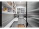 Well-organized pantry featuring white shelving, counter space, and decorative baskets for efficient storage at 5829 W Alyssa Ln, Phoenix, AZ 85083