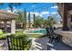 A relaxing lounge area surrounds a serene pool, accented by patio lights and mature landscaping at 60 W Tonto Dr, Chandler, AZ 85248