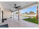 Spacious covered patio with ceiling fans overlooks the pool and turf in this modern backyard oasis at 6116 E Charter Oak Rd, Scottsdale, AZ 85254