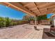 Large backyard showcasing rock landscaping, mature trees, and a covered patio with ample seating at 6305 E Adobe Rd, Mesa, AZ 85205