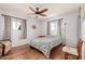 Bright bedroom featuring a ceiling fan, two windows, and hardwood floors at 6305 E Adobe Rd, Mesa, AZ 85205