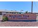 Dreamland Villa, a 55+ Community, welcomes residents with a well-maintained brick sign and lush desert landscaping at 6305 E Adobe Rd, Mesa, AZ 85205
