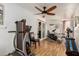 Bright exercise room featuring a ceiling fan, various exercise machines and wood laminate flooring at 6305 E Adobe Rd, Mesa, AZ 85205