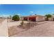 Charming single-story home showcasing a landscaped front yard with a red garage door and decorative concrete block accents at 6305 E Adobe Rd, Mesa, AZ 85205