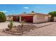 Ranch home with a red garage door and low maintenance desert landscaping at 6305 E Adobe Rd, Mesa, AZ 85205