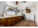 A well-lit utility room featuring a long countertop, cabinets and a washing machine and dryer at 6305 E Adobe Rd, Mesa, AZ 85205