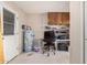 Utility room featuring a water heater, a small desk, and wall-mounted cabinets at 6305 E Adobe Rd, Mesa, AZ 85205