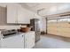 Laundry room with modern appliances, overhead cabinets, and access to the garage at 6314 N 14Th Pl, Phoenix, AZ 85014
