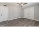 Bedroom with a ceiling fan, gray laminate flooring, and white double-door closet, perfect for a relaxing retreat at 6502 N Central Ave # A103, Phoenix, AZ 85012
