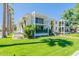 Modern two-story condo building with balconies, palm trees, a lawn, and walkways at 6502 N Central Ave # A103, Phoenix, AZ 85012