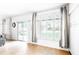 Light-filled living room featuring wood-look floors, white walls, and a sliding glass door leading to the backyard at 696 W Del Rio St, Gilbert, AZ 85233