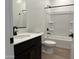 Modern bathroom with dark vanity, quartz countertop, and tub-shower combo and tiled flooring at 7694 W Saddlehorn Rd, Peoria, AZ 85383
