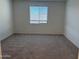 Cozy bedroom featuring plush carpeting and a bright window at 7694 W Saddlehorn Rd, Peoria, AZ 85383