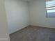Cozy, carpeted bedroom with a window offering natural light and view of the backyard at 7694 W Saddlehorn Rd, Peoria, AZ 85383