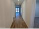 Well-lit hallway with wood-look tile flooring leading to the living spaces and featuring neutral paint at 7694 W Saddlehorn Rd, Peoria, AZ 85383