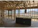 Interior view of a home under construction, showing exposed wooden beams, wiring, and scenic desert landscape at 7694 W Saddlehorn Rd, Peoria, AZ 85383
