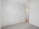 A clean, carpeted bedroom with an open door to another room with wood-look flooring at 7701 W Avenida Del Rey --, Peoria, AZ 85383