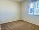 Bright bedroom with neutral carpet, white walls, and a window providing ample natural light at 7701 W Avenida Del Rey --, Peoria, AZ 85383